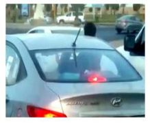 “المرور” يستدعي سائقاً سمح لطفل مرافق له بالخروج من نافذة السيارة
