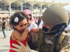 بالصورة .. ضابط سعودي يحتضن طفلة يمنية في مطار عدن