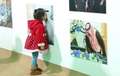 طفلة تطبع قبلة على صورة للملك سلمان في عفوية تامة- صورة