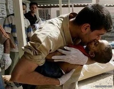 صورة مبكية لمواطن سوري يقبل طفلتة المقتولة